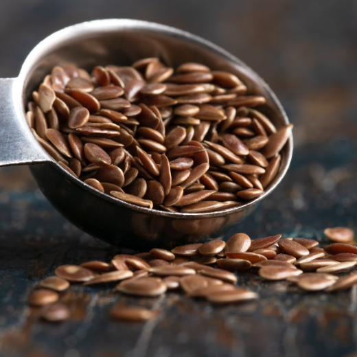 Flaxseeds in a spoon and some seeds lying down